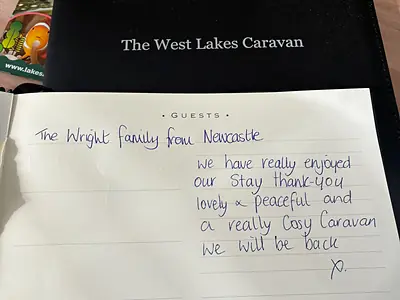 The guest book open on the table with a handwritten entry from a family who stayed at Easter.